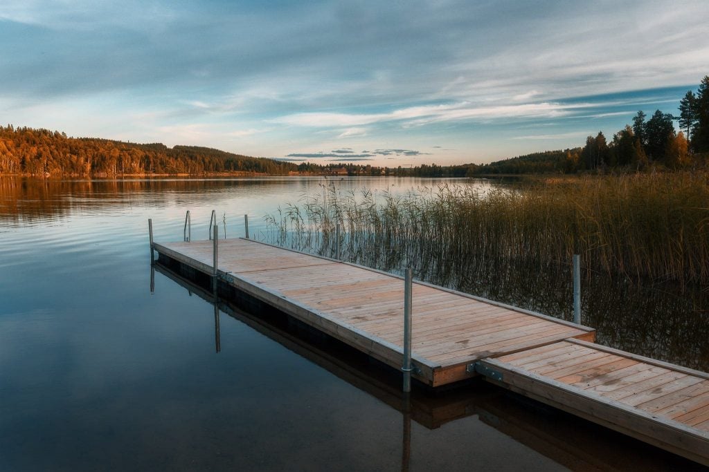En brygga i en spegelblank sjö någonstans i Dalarna - Ludwig Sörmlind